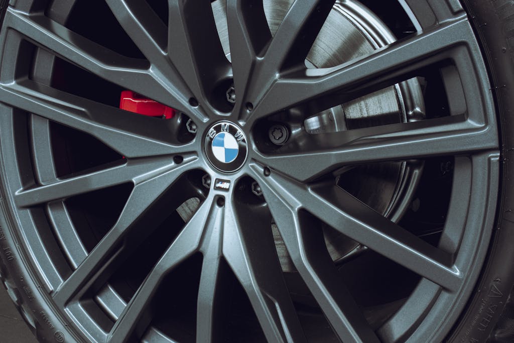 Close-up of a luxury car alloy wheel, featuring intricate metal design and bolts.